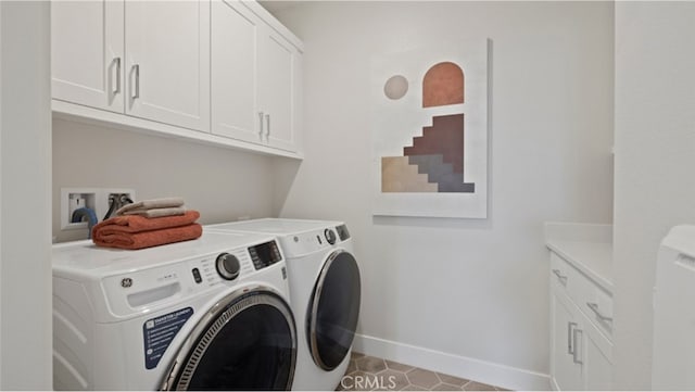 clothes washing area featuring washing machine and clothes dryer and cabinets