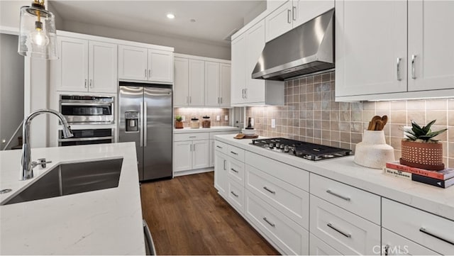 kitchen featuring white cabinetry, sink, dark hardwood / wood-style floors, backsplash, and appliances with stainless steel finishes