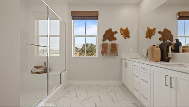 bathroom featuring vanity, a shower with door, and a wealth of natural light