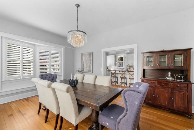 dining area with a chandelier and light hardwood / wood-style floors