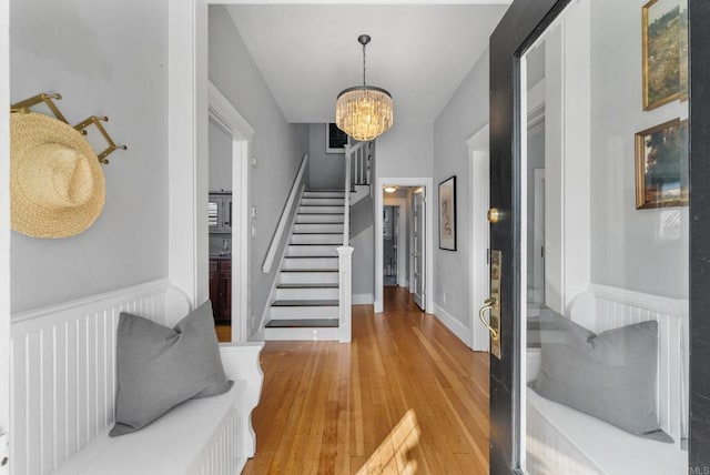 foyer entrance with light hardwood / wood-style flooring and an inviting chandelier