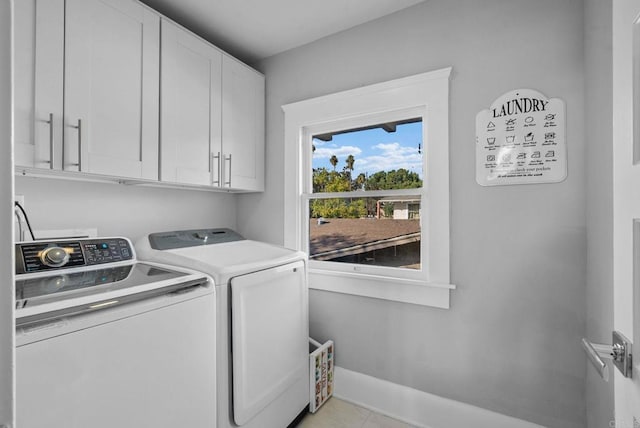 washroom with separate washer and dryer, light tile patterned flooring, and cabinets