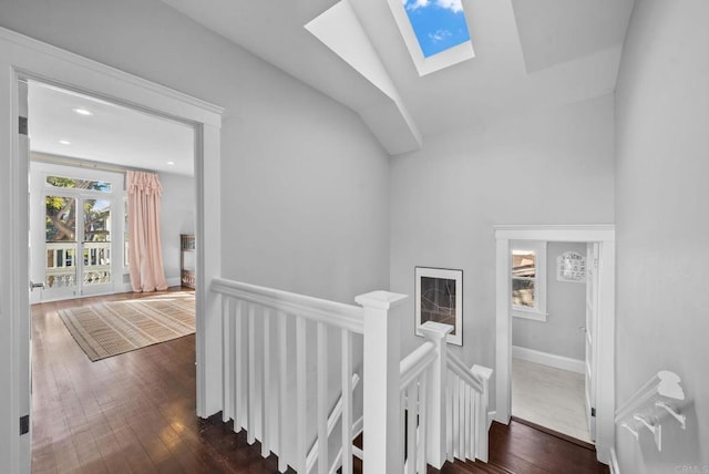 stairs featuring hardwood / wood-style flooring and vaulted ceiling with skylight