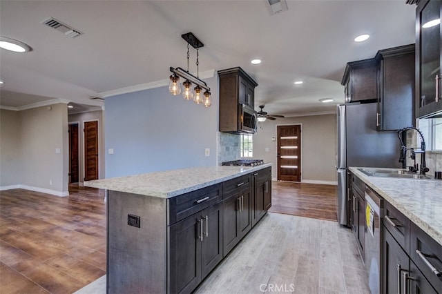 kitchen with pendant lighting, a center island, light wood-type flooring, and stainless steel appliances