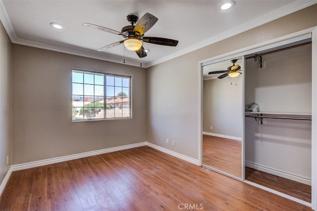 unfurnished bedroom featuring hardwood / wood-style floors, a closet, ceiling fan, and ornamental molding