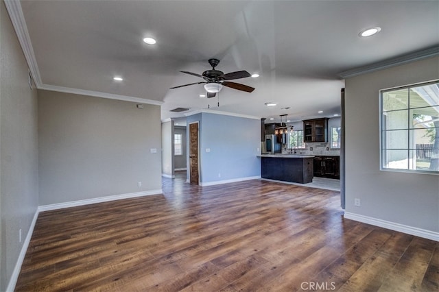 unfurnished living room featuring ceiling fan, dark wood-type flooring, and ornamental molding