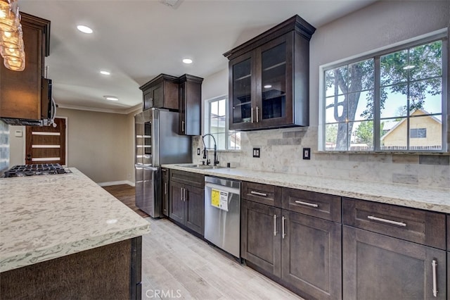 kitchen with a healthy amount of sunlight, sink, stainless steel appliances, and light hardwood / wood-style flooring