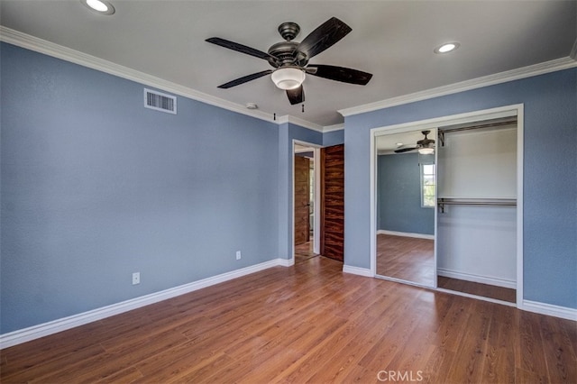 unfurnished bedroom featuring hardwood / wood-style flooring, ceiling fan, ornamental molding, and a closet