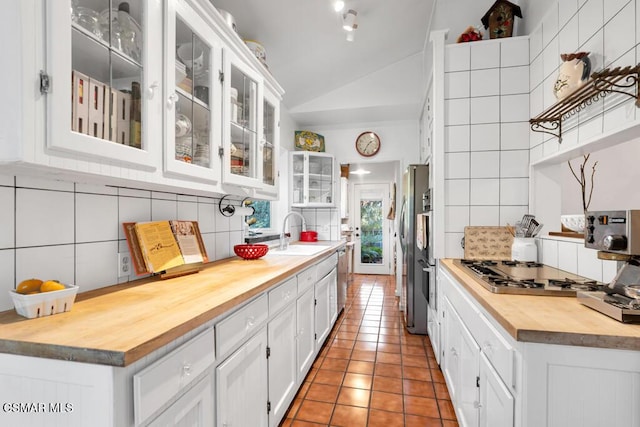 kitchen featuring butcher block countertops, white cabinetry, and tasteful backsplash