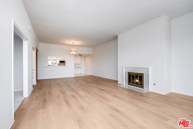 unfurnished living room with light hardwood / wood-style flooring and ornamental molding