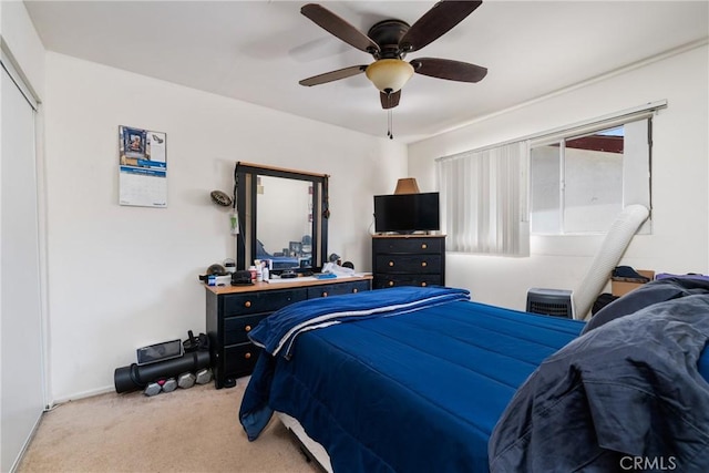 carpeted bedroom with ceiling fan and a closet