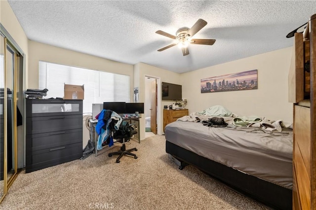 carpeted bedroom with ceiling fan, a closet, and a textured ceiling