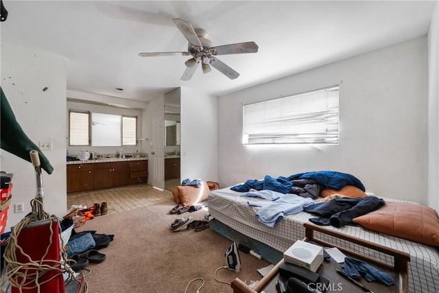 carpeted bedroom featuring ceiling fan and ensuite bath