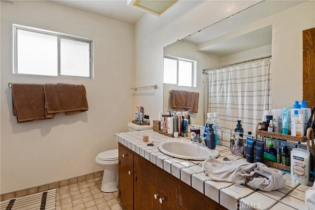 bathroom featuring curtained shower, toilet, and vanity