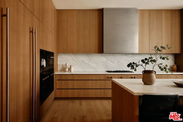 kitchen with black oven, wooden counters, light wood-type flooring, and tasteful backsplash