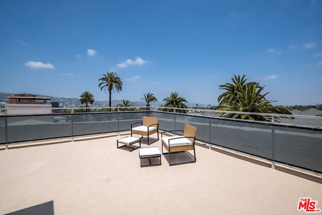 view of patio featuring a balcony and a water view