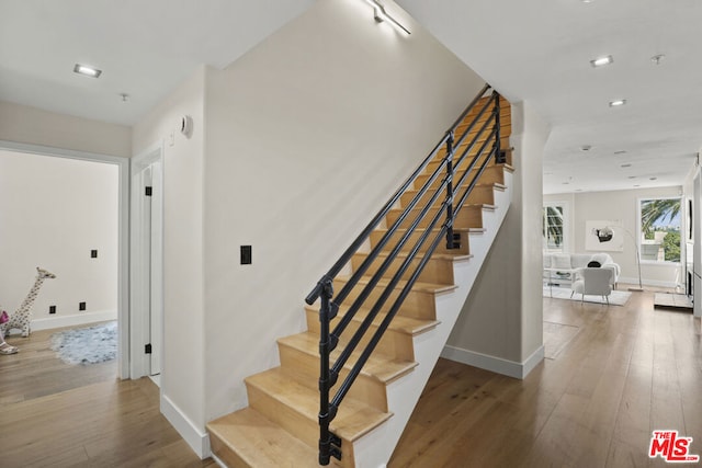 staircase with hardwood / wood-style floors