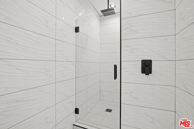 bathroom featuring a shower with door