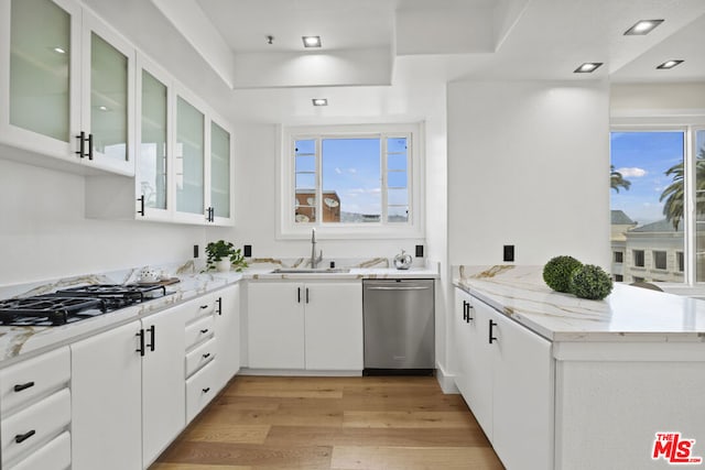 kitchen featuring white cabinetry, sink, stainless steel appliances, light hardwood / wood-style flooring, and kitchen peninsula