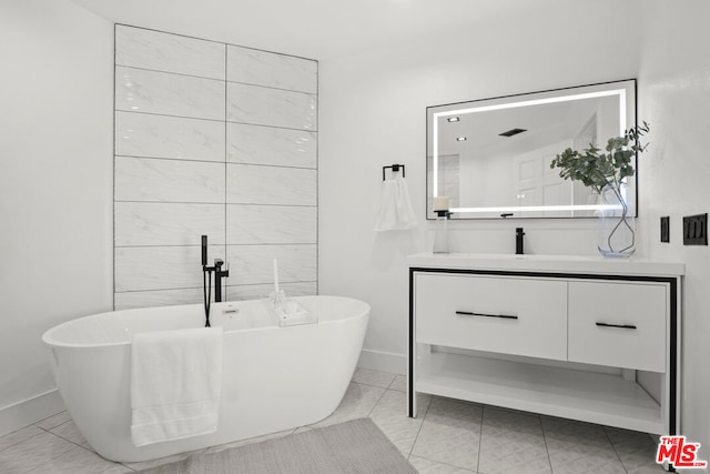 bathroom featuring a bathing tub, tile patterned flooring, and vanity