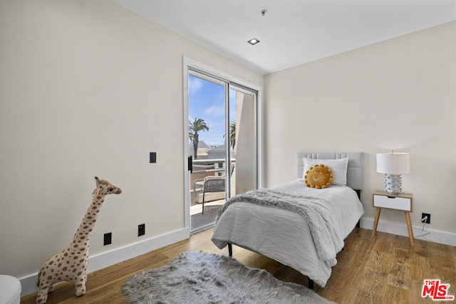 bedroom with hardwood / wood-style floors and access to outside