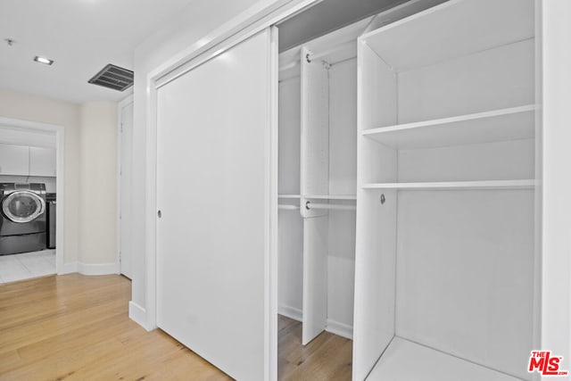 spacious closet featuring hardwood / wood-style flooring and washer / clothes dryer