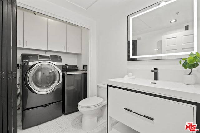 laundry area featuring washer and clothes dryer, light tile patterned flooring, cabinets, and sink