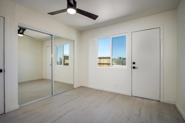 unfurnished bedroom with ceiling fan, a closet, and light hardwood / wood-style floors