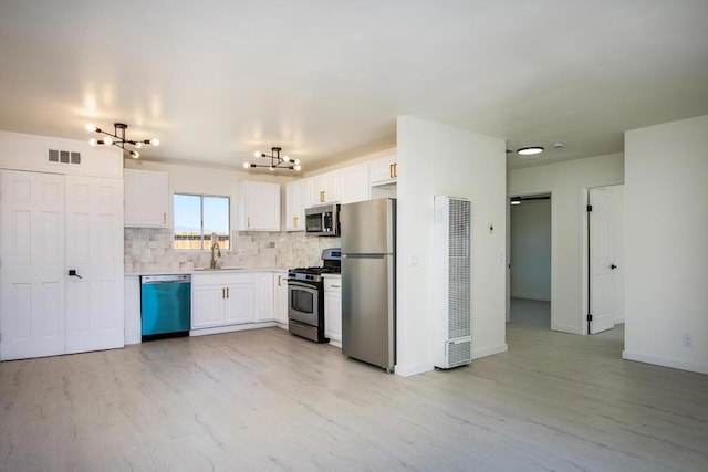 kitchen featuring sink, a notable chandelier, light hardwood / wood-style floors, white cabinetry, and stainless steel appliances