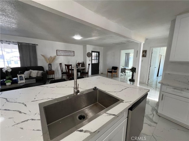 kitchen featuring light stone counters and white cabinets