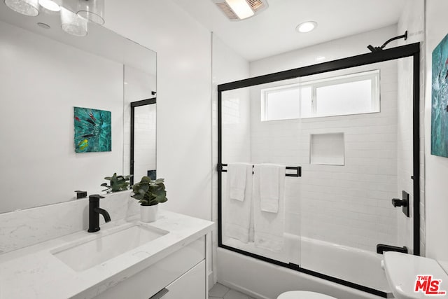 full bathroom featuring vanity, toilet, and bath / shower combo with glass door