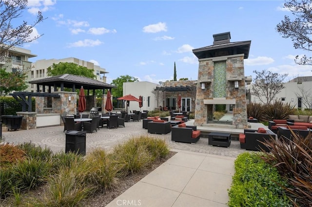 view of property's community featuring an outdoor kitchen, a patio area, and outdoor lounge area