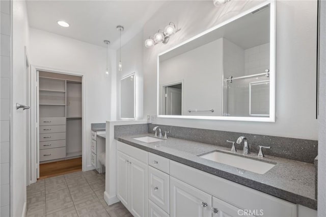 bathroom featuring a shower with shower door, vanity, and tile patterned flooring