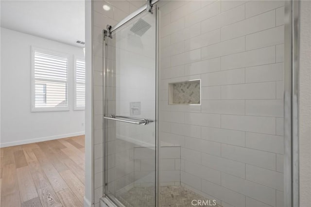 bathroom with hardwood / wood-style floors and a shower with door