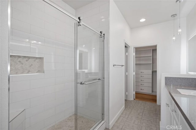 bathroom with a shower with shower door and vanity