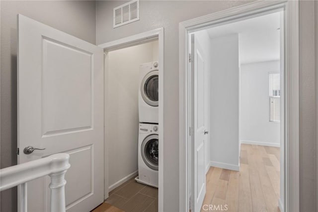 laundry area featuring light hardwood / wood-style floors and stacked washer and dryer