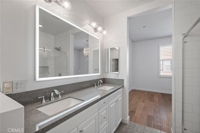 bathroom with hardwood / wood-style flooring, a shower with shower door, and vanity