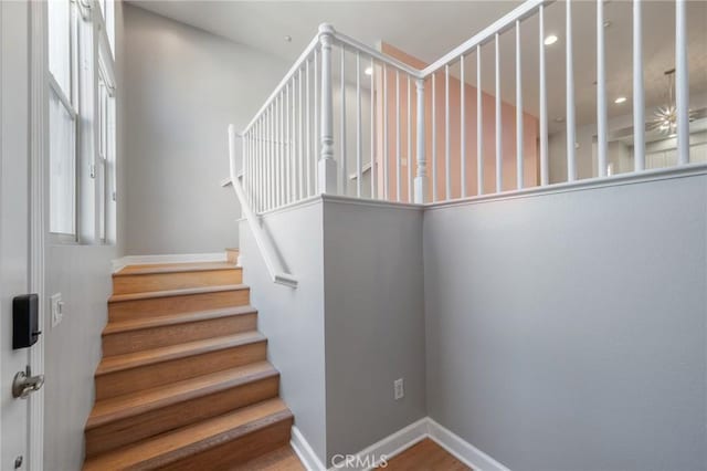 stairs featuring hardwood / wood-style flooring and a healthy amount of sunlight