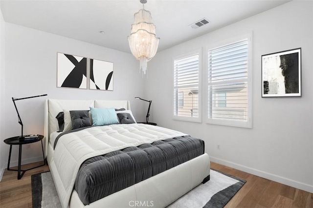 bedroom featuring hardwood / wood-style floors and a notable chandelier