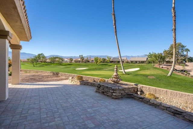 view of community featuring a patio area, a yard, and a mountain view