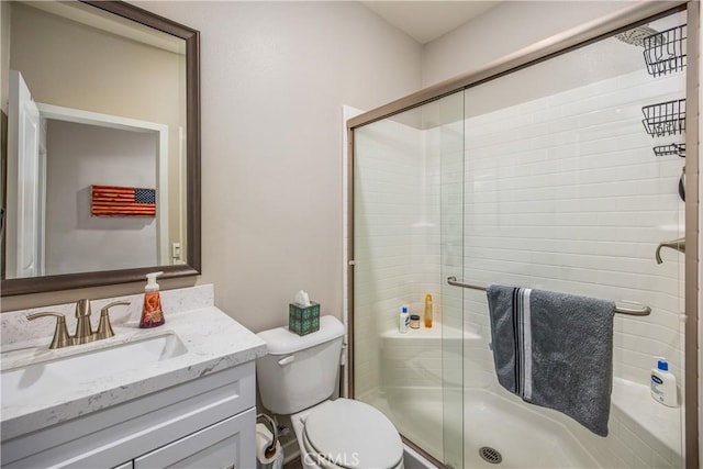 bathroom featuring vanity, an enclosed shower, and toilet