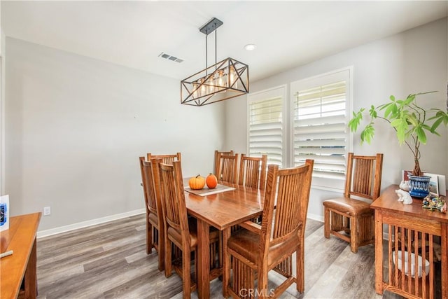 dining area featuring hardwood / wood-style flooring and an inviting chandelier