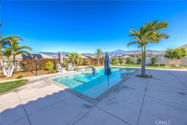 view of pool featuring an in ground hot tub, a mountain view, and a patio area