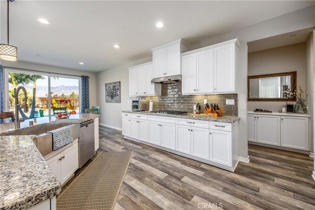 kitchen with white cabinetry, stainless steel appliances, and hanging light fixtures