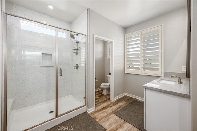 bathroom featuring plenty of natural light, vanity, wood-type flooring, and toilet