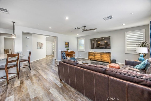 living room with ceiling fan and light hardwood / wood-style floors