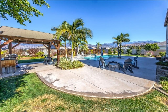 view of patio / terrace with a fenced in pool, a mountain view, and a gazebo