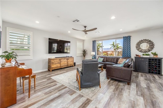 living room featuring hardwood / wood-style floors and ceiling fan