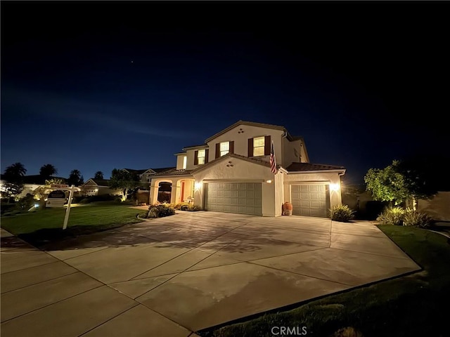 mediterranean / spanish-style house featuring a garage and a lawn