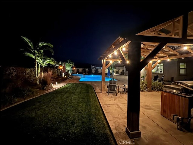 yard at night featuring a patio